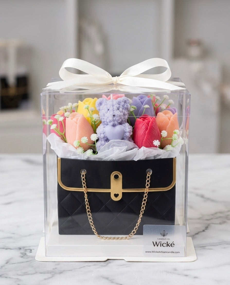 Decorative set with teddy bears and flowers in a clear box on a marble surface, featuring the brand 'Wicke'.