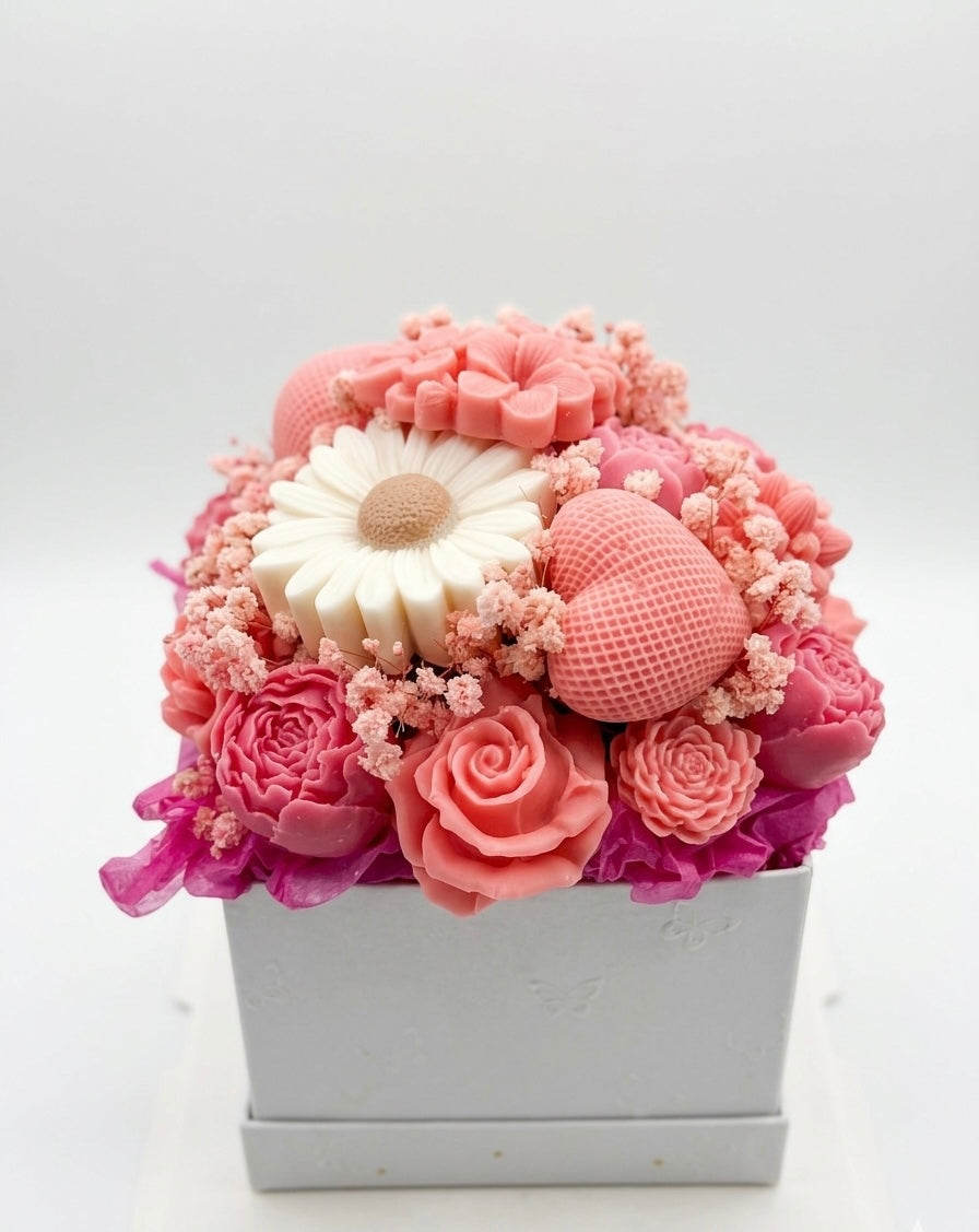 Pink and white floral soap arrangement in a box on a light gray background