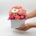 Pink and white floral soap arrangement in a box on a light gray background