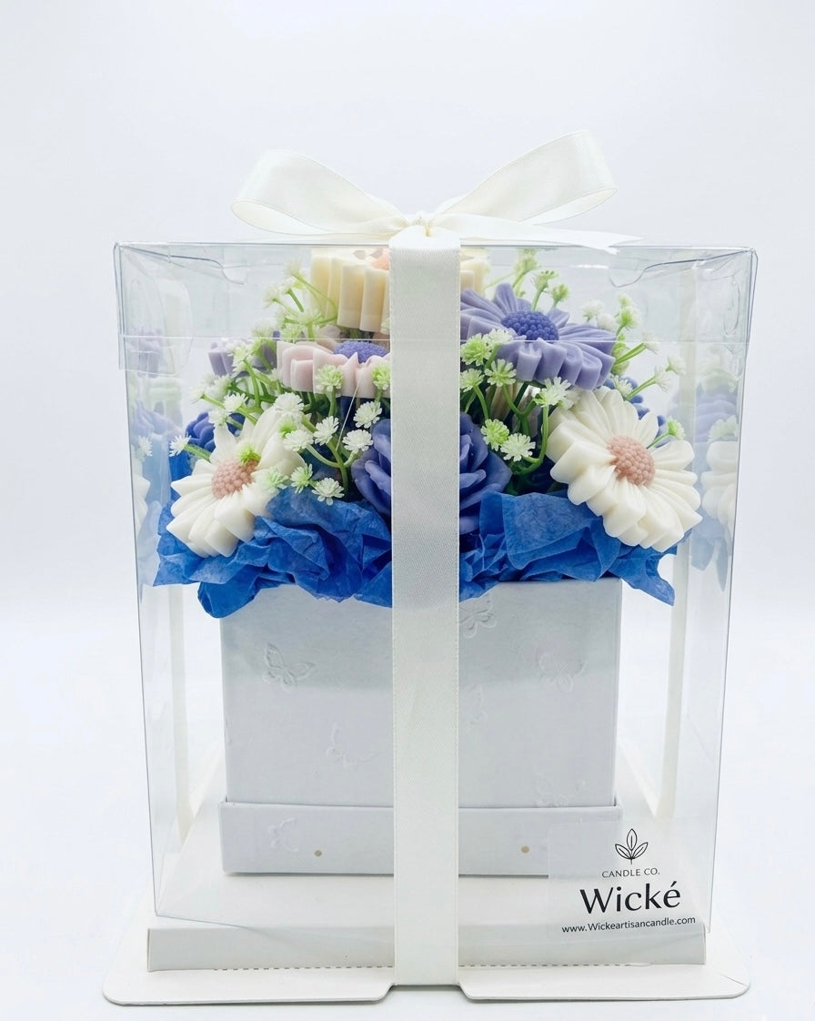 Floral arrangement in a clear box with 'Wicke' branding on a white background