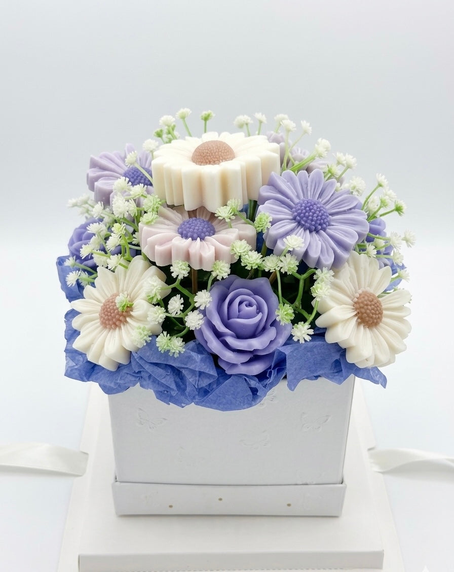 Soap flower arrangement in a white box on a light gray background