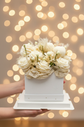 White floral arrangement in a box on a white background