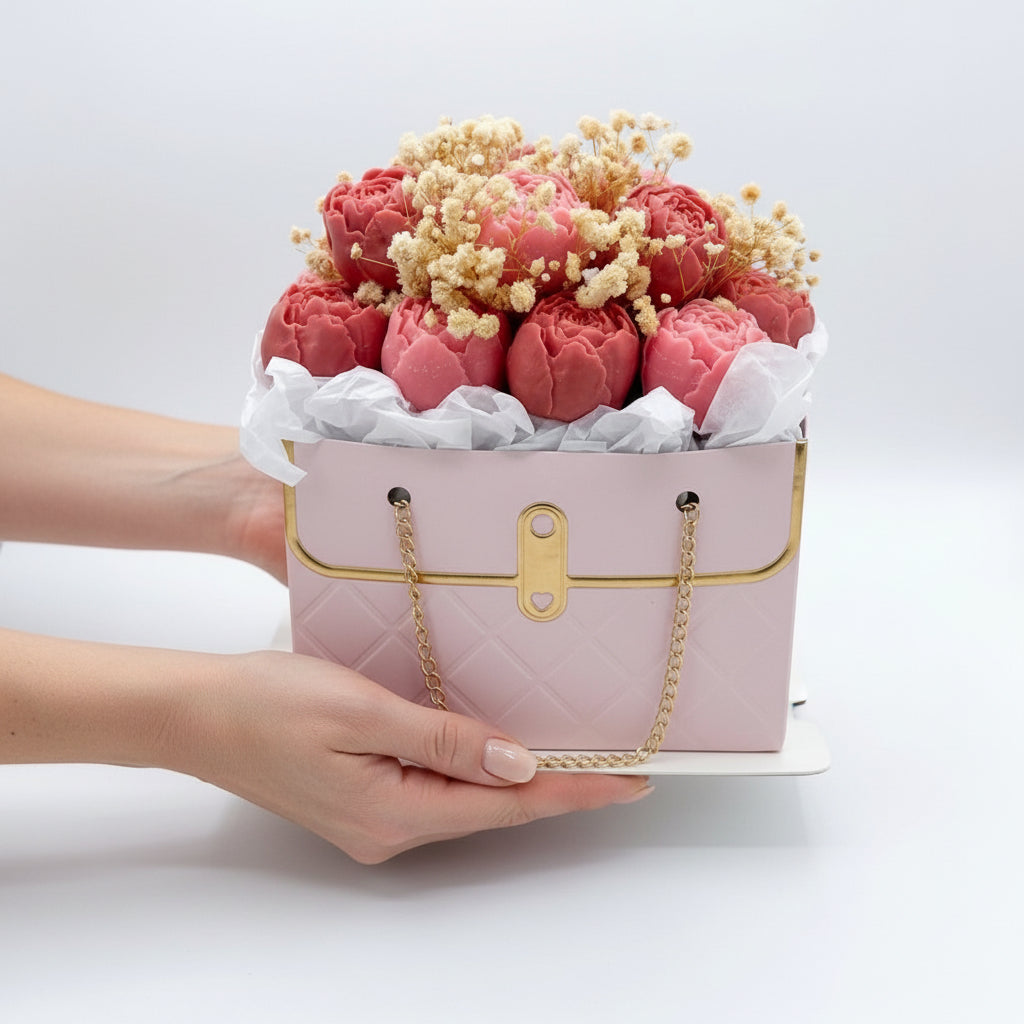 Pink handbag-shaped box with flowers on a white background