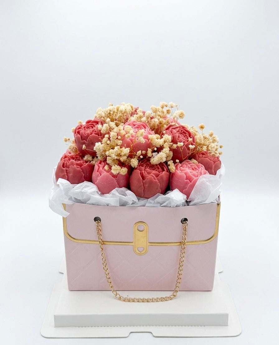Pink handbag-shaped box with flowers on a white background