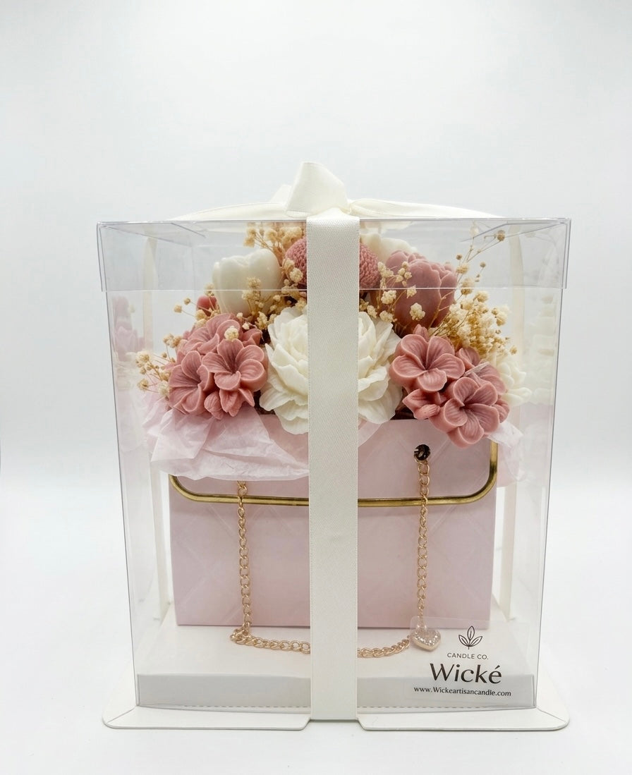 Pink handbag with floral arrangement and 'Wicke' branding on a white background