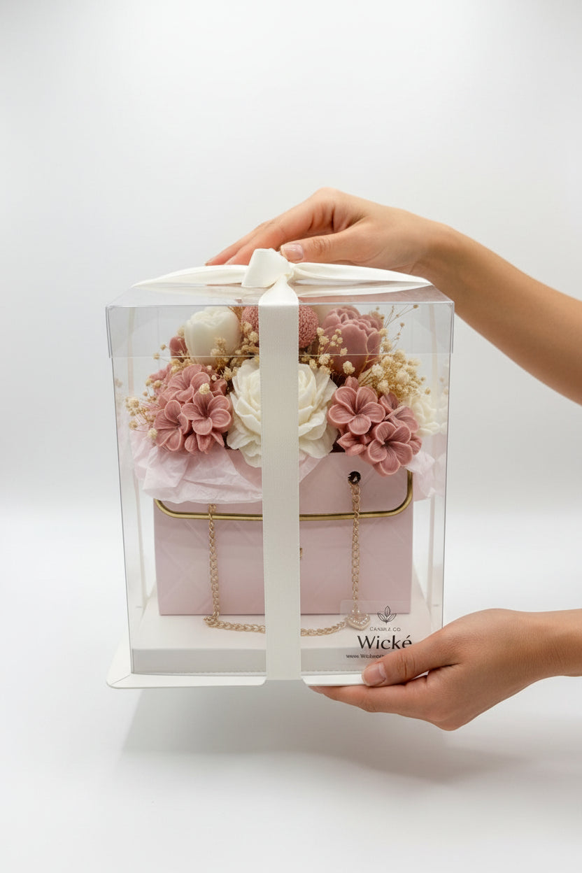 Pink handbag with floral arrangement and 'Wicke' branding on a white background