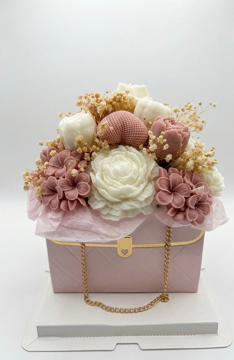 Pink handbag with floral arrangement on a white background