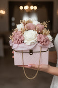 Pink handbag with floral arrangement on a white background