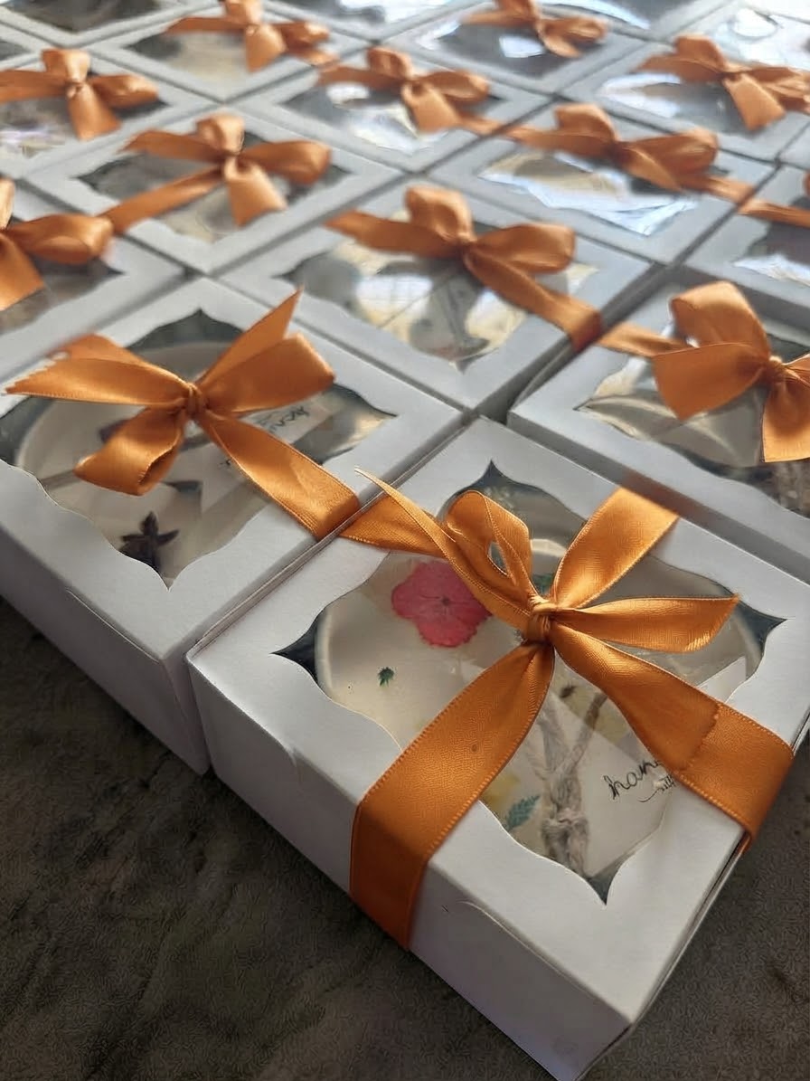 Boxed pressed flower candle keepsakes tied with ribbon, a gift for bridesmaids