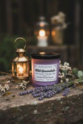 A purple glass jar candle with a black lid and a white label reading 'WICK E ARTISAN Wild Lavandula' on a white background.