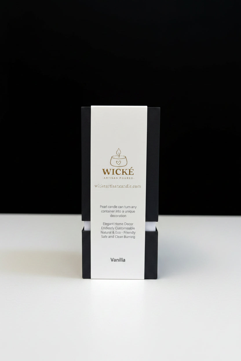 A single box of Wické Vanilla Pearl Wax Candle centered against a solid black background, sitting on a clean white surface with sharp, professional studio lighting highlighting the minimalist product design.